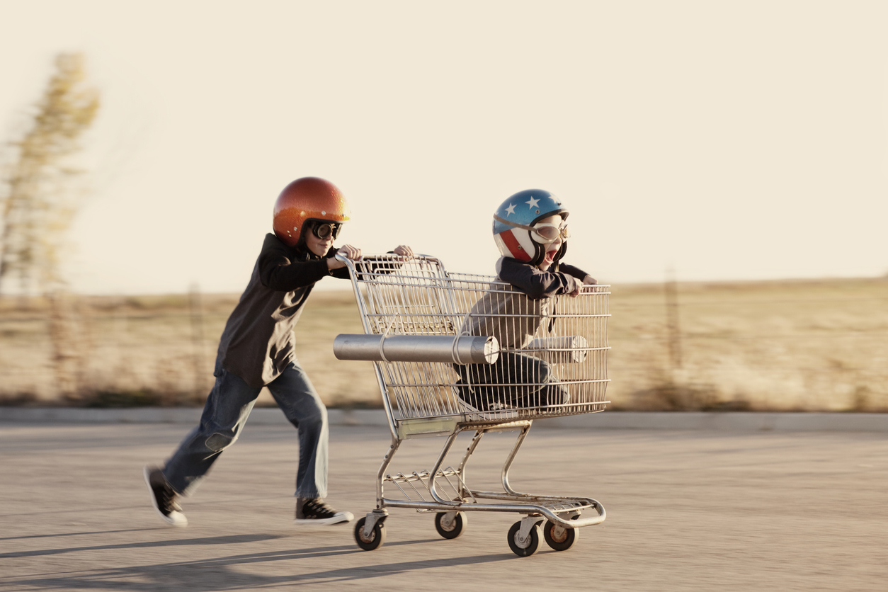 Boys in Helmets Race a Shopping Cart